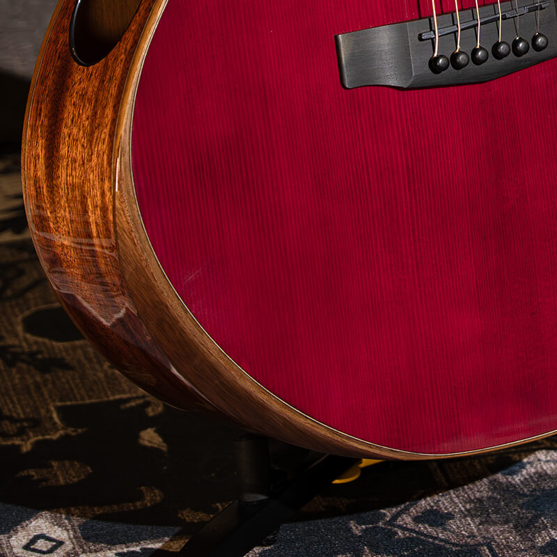 close-up of the body of a Cort Modern Burst guitar resting on a carpet