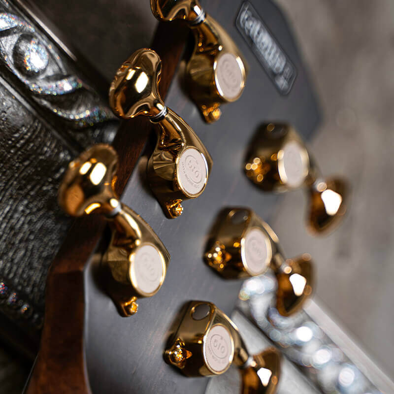 back of the headstock of a Cort Modern Burgundy guitar showing tuning pegs